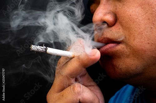 Man smoking a cigarette, Image of cigarette in hand with smoke
