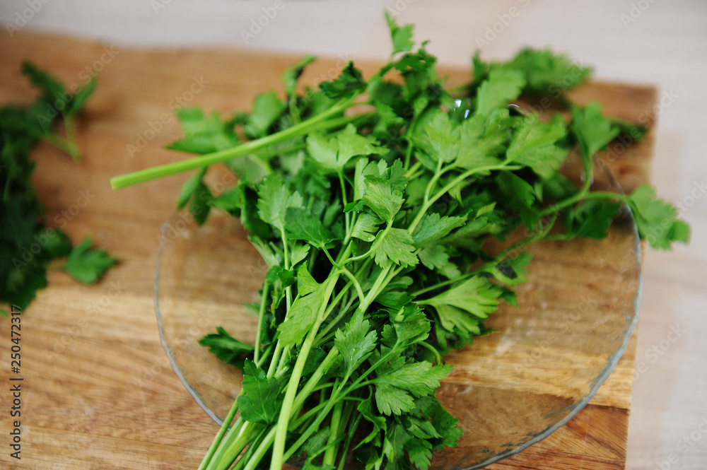 Bunch of fresh juicy parsley on a wooden cutting board closeup. Natural vitamins, background Bunch of fresh juicy parsley on a wooden cutting board closeup. Natural vitamins, background