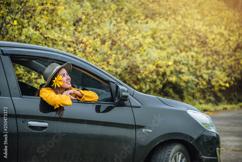 Asian women are on vacation. Drive happily traveling to the Mexican sunflower flower garden in Thailand.