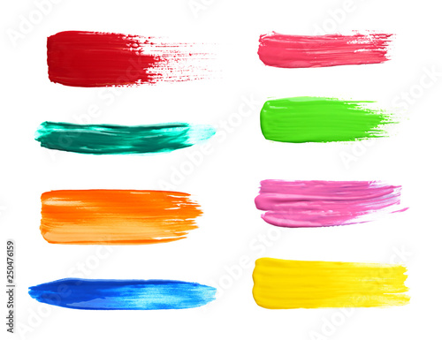 Set with abstract brushstrokes of different bright paints on white background, top view