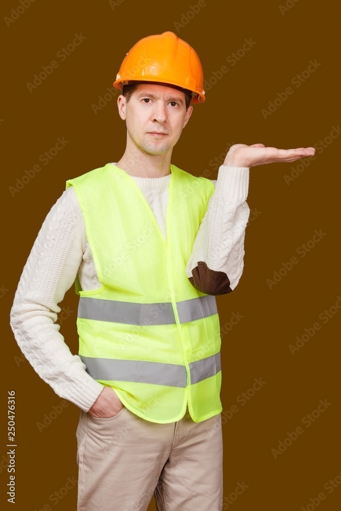 the man in a construction helmet, a vest, raised a palm up the man in a construction helmet, a vest, raised a palm up