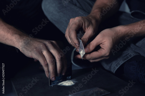 Young addicted men taking drugs, closeup of hands