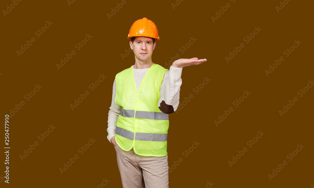 the man in a construction helmet, a vest, raised a palm up the man in a construction helmet, a vest, raised a palm up