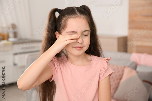 Quadro em tela Little girl rubbing eye at home. Annoying itch