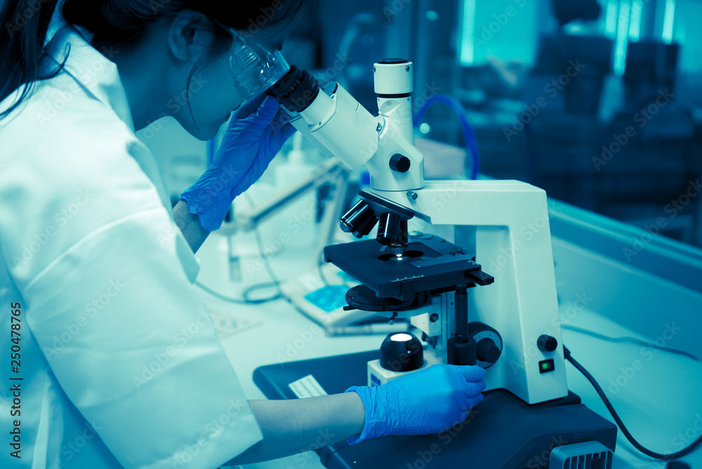 Young asian scientist looking through a microscope in a laboratory.Thailand people doing some research. Young asian scientist looking through a microscope in a laboratory.Thailand people doing some research.
