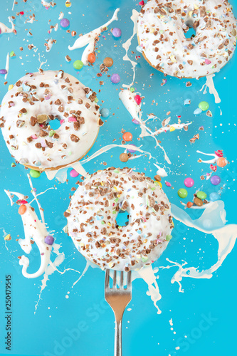 Floating in the air donuts on a blue background. Sweets, pastries.	