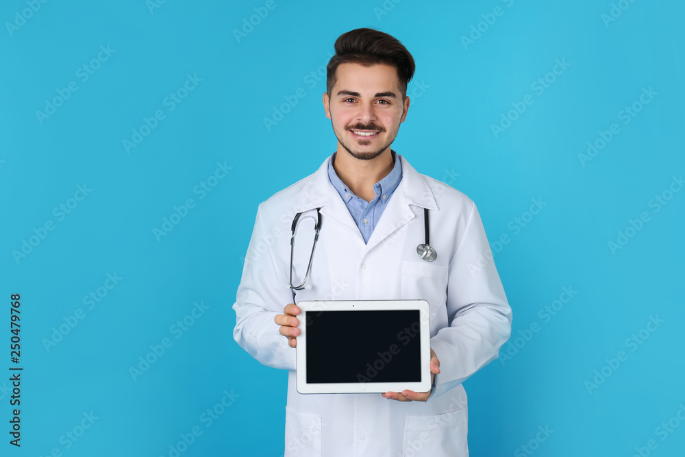Young medical student with tablet on color background. Space for text Young medical student with tablet on color background. Space for text