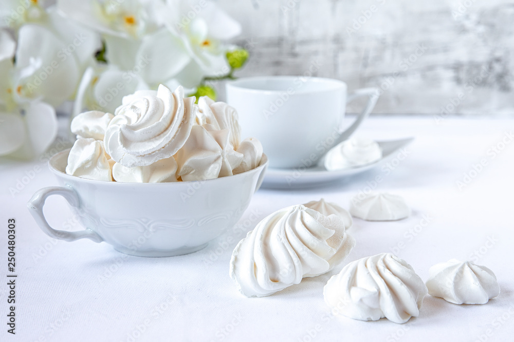 Meringues. Protein sugar cake for tea or coffee. Light background.White morning. Candy