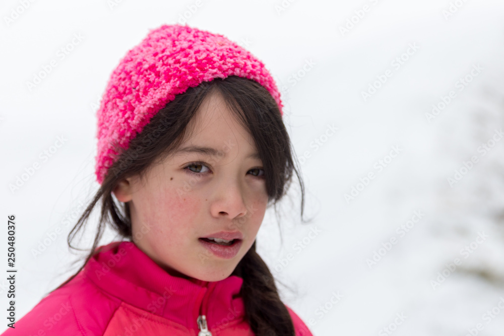 Young Asian girl with pink hat in snow Young Asian girl with pink hat in snow