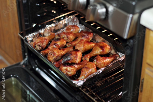 Freshly baked barbecue chicken drumsticks from the oven.