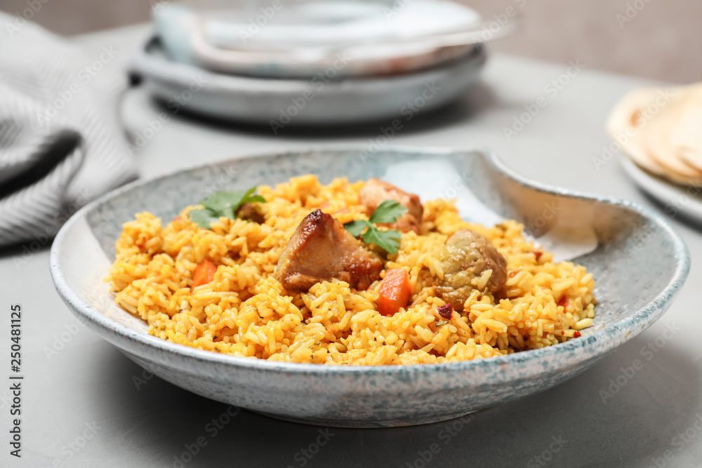 Plate of tasty rice pilaf with meat on table