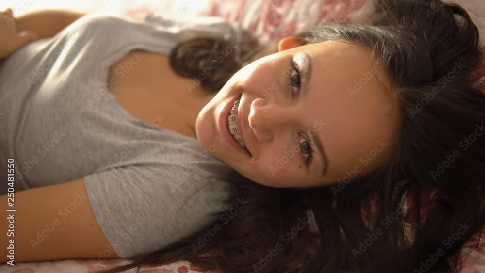 Cute teen natural beauty girl with bright smile laying on the bed Cute teen natural beauty girl with bright smile laying on the bed
