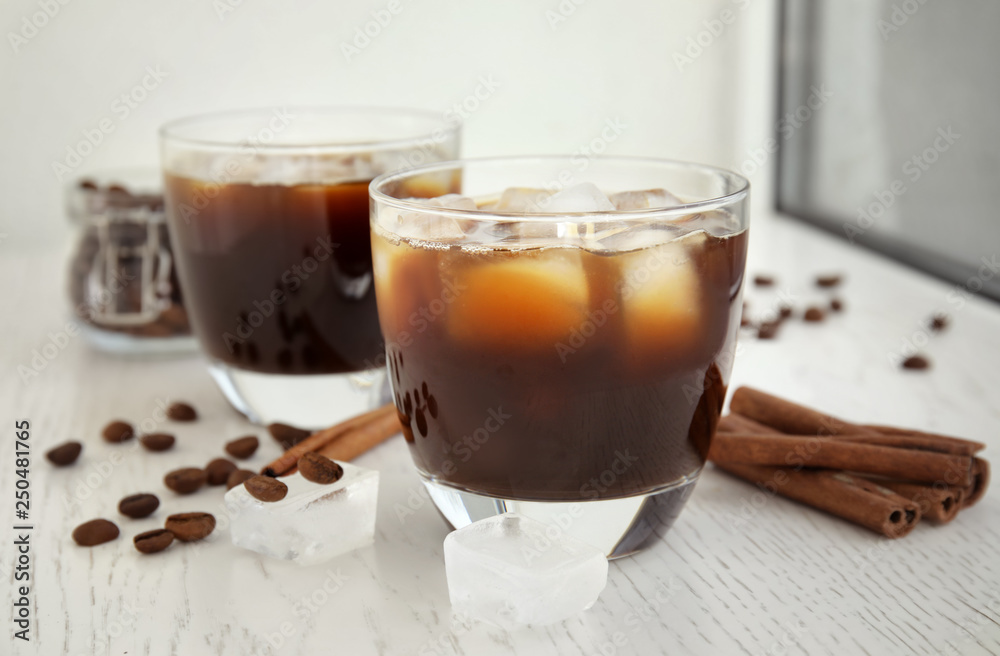 Glasses of coffee drink with ice cubes on table