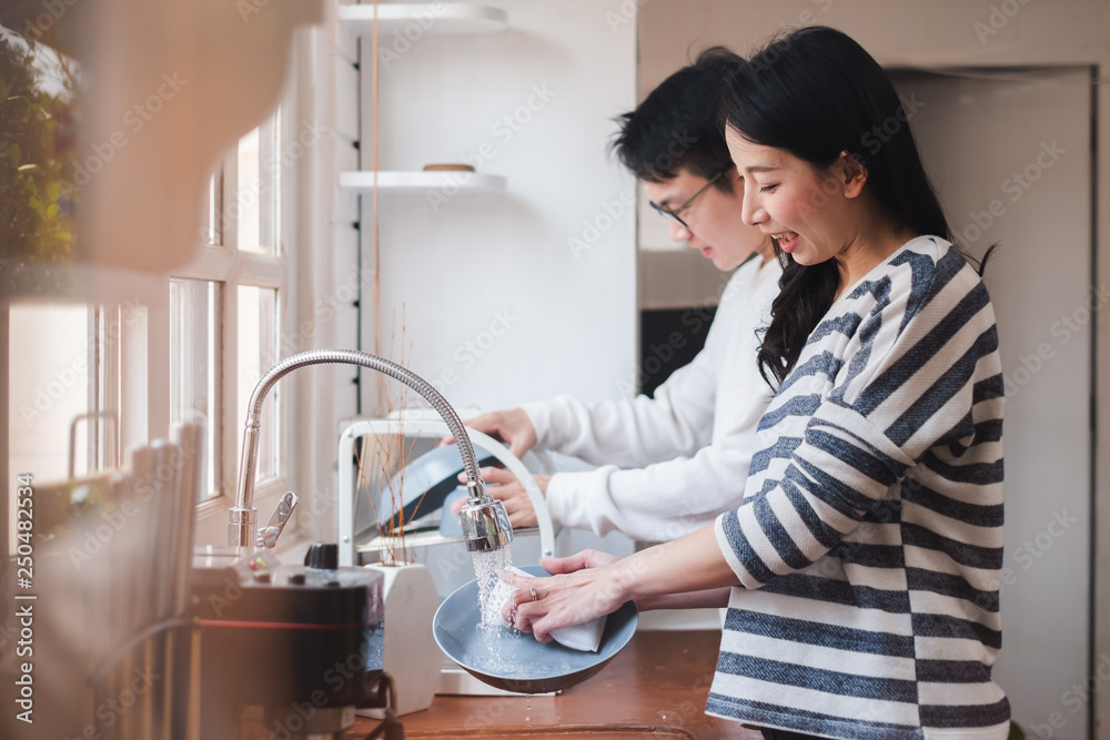 Asian couple family washing dishes together at kitchen - obrazy, fototapety, plakaty 