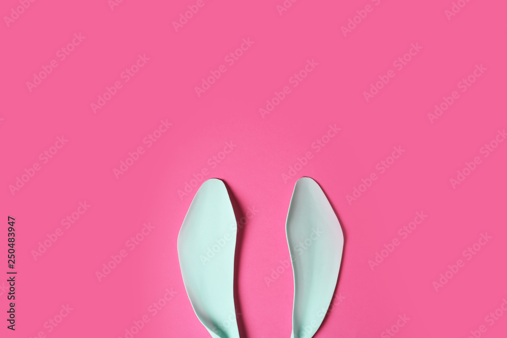 Funny Easter bunny ears on color background, top view with space for text Funny Easter bunny ears on color background, top view with space for text