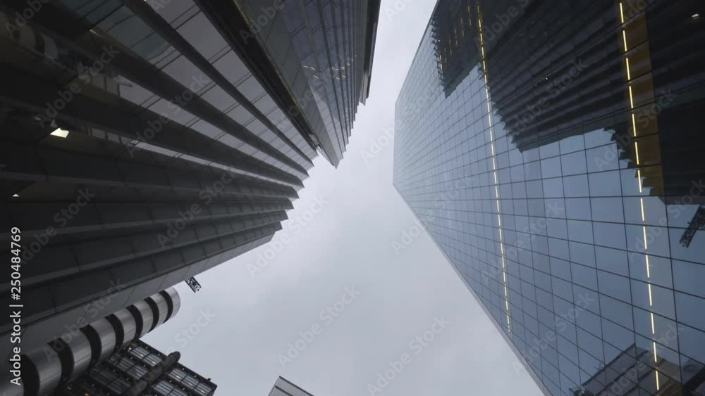 A spinning low angle view of high raise glass office buildings.