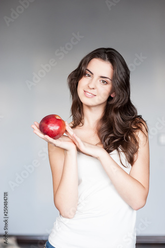 smiling woman  holding red apple. studio isolated portrait.