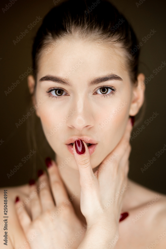 Portrait of young charming girl with natural makeup holding her hands on her face Portrait of young charming girl with natural makeup holding her hands on her face