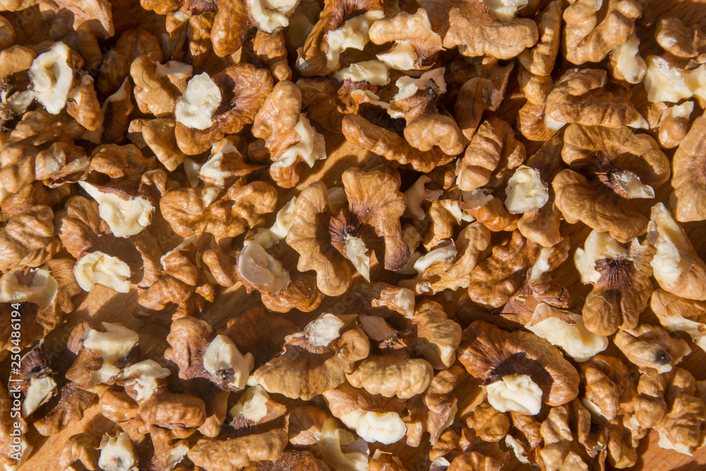Closeup of Peeled Walnuts pile. Walnuts Background on wooden cutting board. Selective Focus, nuts with many different textures Closeup of Peeled Walnuts pile. Walnuts Background on wooden cutting board. Selective Focus, nuts with many different textures