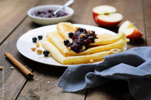 Crepes with Black Currant Jam on Dark Wooden Background