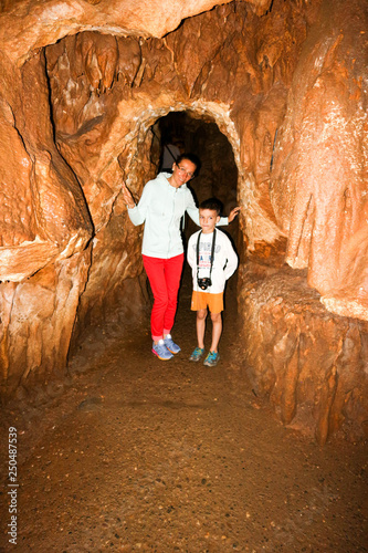 Fotografie Tourist mother and son stay in the cave passage, Koutouki, Athens, Greece