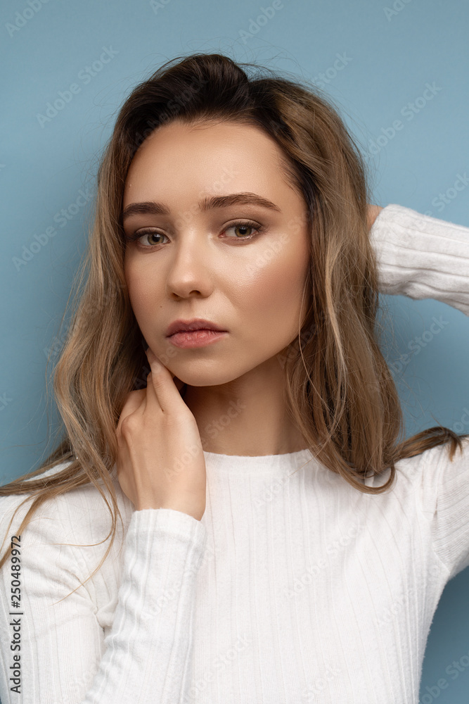 Beautiful model with curly hair on blue background and bright makeup Beautiful model with curly hair on blue background and bright makeup