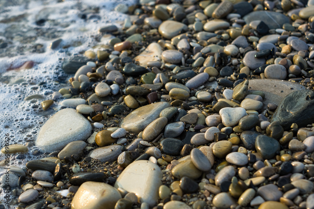 pebble stones on the sea beach, the rolling waves of the sea with foam pebble stones on the sea beach, the rolling waves of the sea with foam