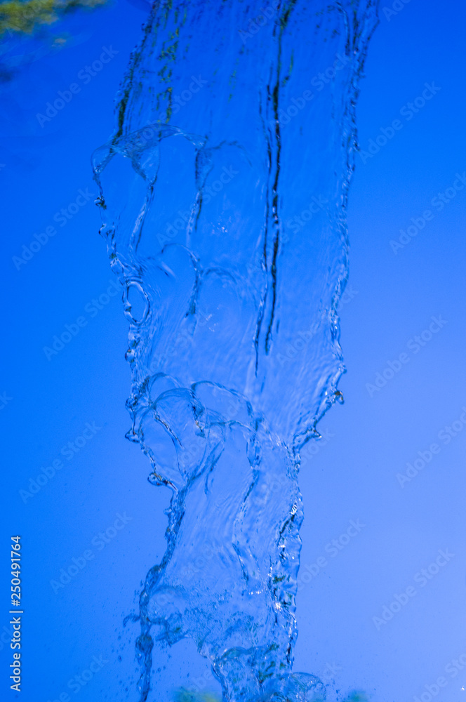 transparent falling water vertical flows, close up transparent falling water vertical flows, close up