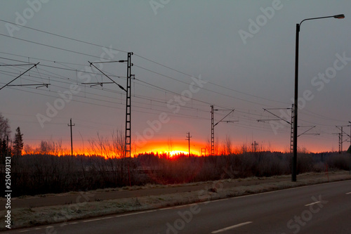 Beautiful sunrise at road and railroad at autumn in Finland.