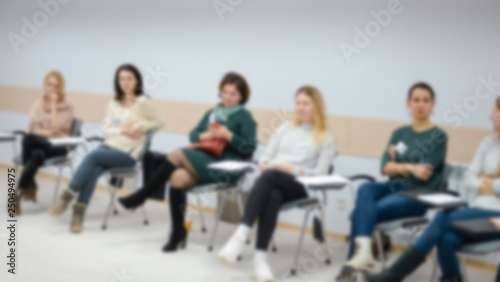 A group of people at a seminar, conference in the blur effect.