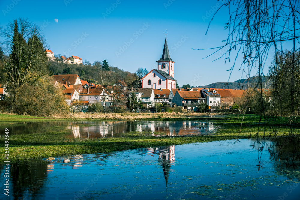 Michaelskirche, Schloss Reichenberg und das Dorf Reichelsheim spiegeln sich im Winterweiher der Stockwiese