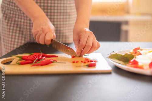 woman in the kitchen cutting chili