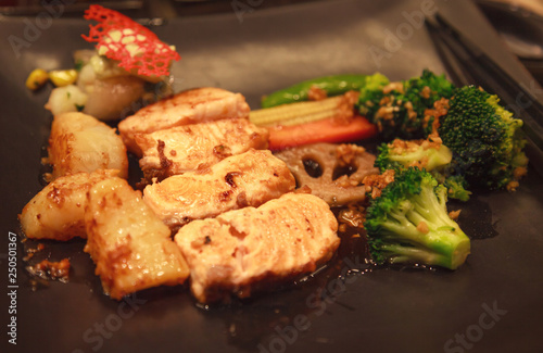 Fresh Assorted Seafood, Salmon Fillet, Scallop and Vegetable Teppanyaki Grill (Japanese cuisine that uses an iron griddle or hot fry pan to cook food) in traditional steakhouse. Food Cooking concept