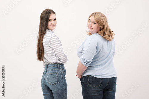 Fotografija Two girls, fat and slender, show the backs of their ass into the camera