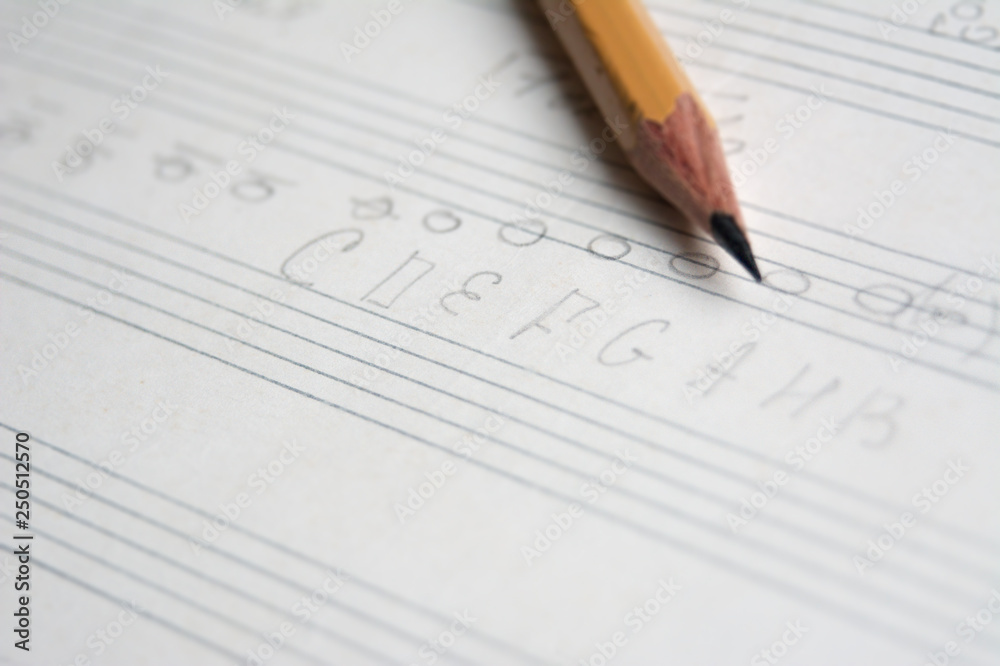 pencil on a musical notebook close-up, abstract musical notes and chords, musical background pencil on a musical notebook close-up, abstract musical notes and chords, musical background