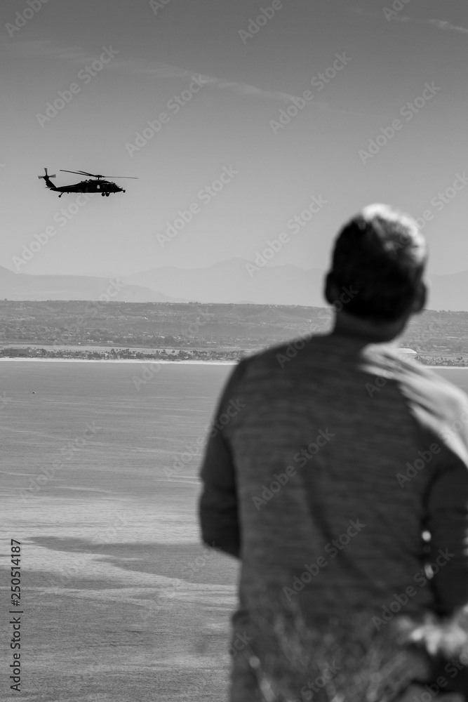 man enjoying ocean view with helicopter