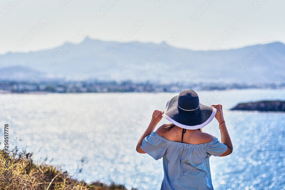 Beautiful woman in beach hat enjoying sea view with blue sky at sunny day in Bodrum, Turkey. Vacation Outdoors Seascape Summer Travel Concept