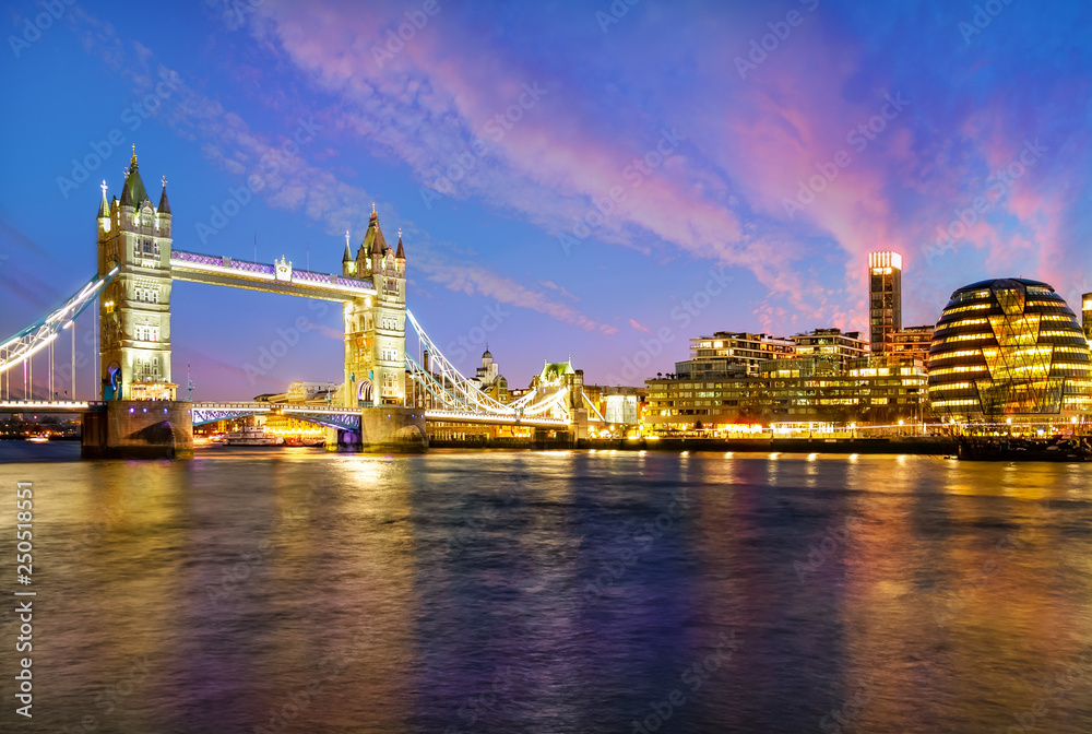 London cityscape at night with famous Tower Bridge illuminated and reflected in Thames river in England 