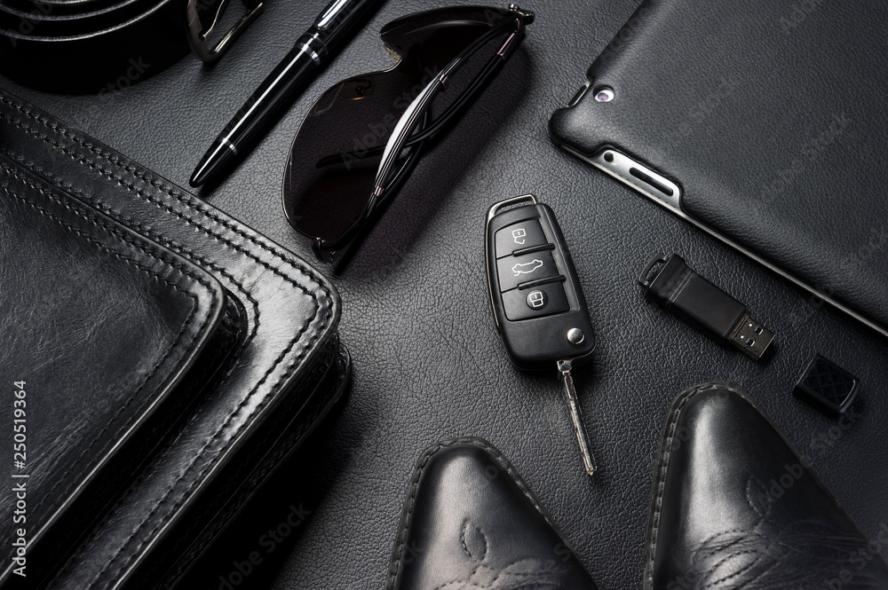 accessories in business style, gadgets, clothes, shoes and other businessman objects on leather black background, fashion industry, selective focus Photo | Adobe Stock
