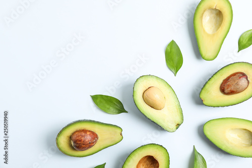 Flat lay composition with ripe avocados on white background, space for text. Top view photo