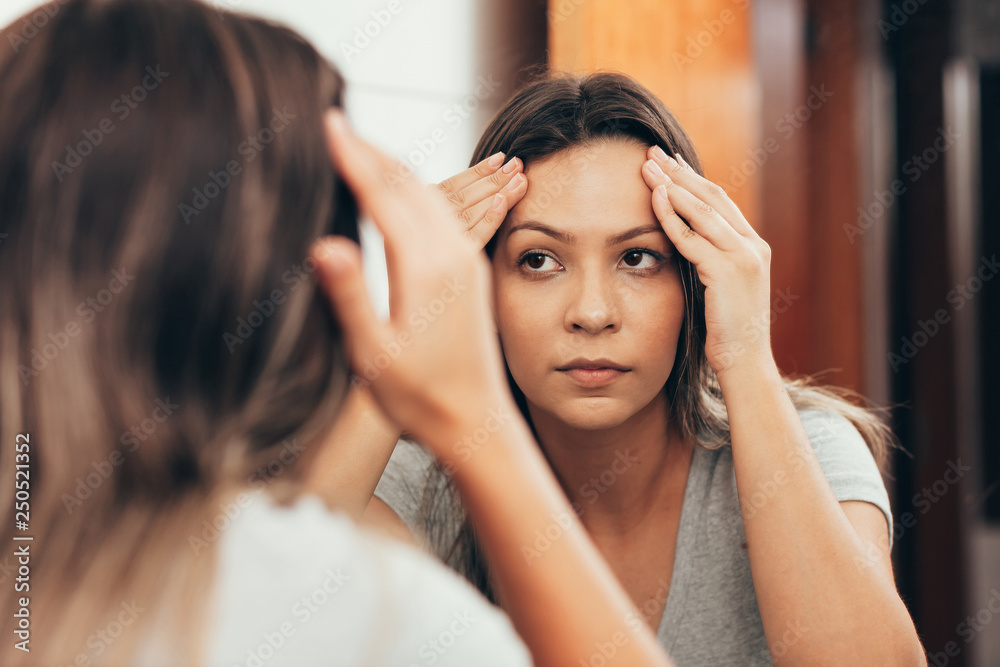 Young woman checking her skin. Skin care concept Young woman checking her skin. Skin care concept
