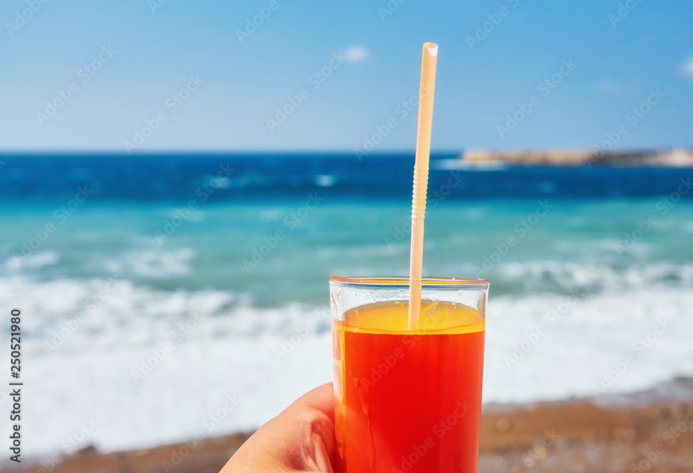 fresh drink in man's hand on the background of the exotic beach fresh drink in man's hand on the background of the exotic beach