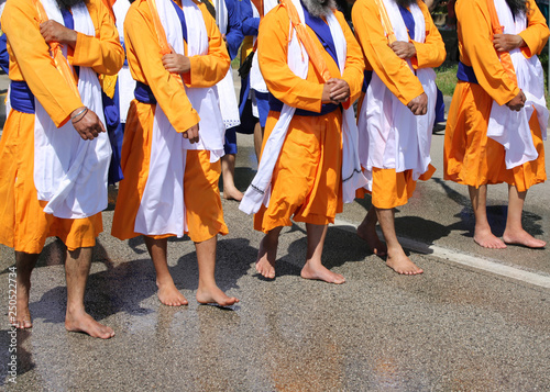 sikh men with orange clothes during religious ceremony photo