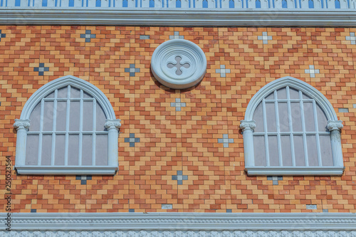 Abstract art of balconies which decorated in circle shape above arch window on brick wall background.