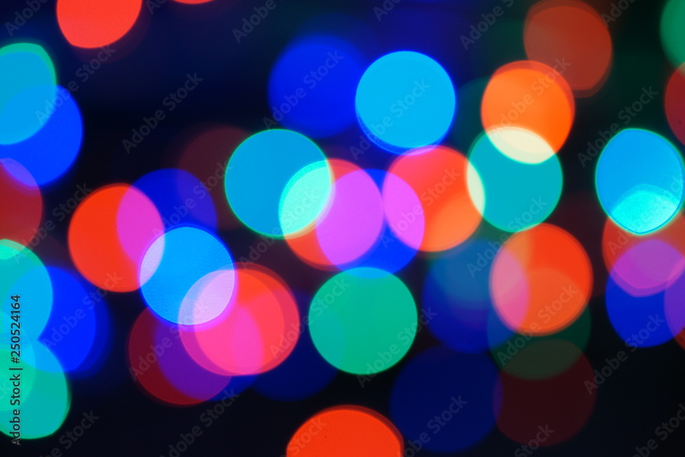 Multi-color blue holiday garland. Garland is blurred. Many big colorful round lights. Fully defocused photo. Blurred background and foreground. Holiday mood. New Year and Christmas is coming. Multi-color blue holiday garland. Garland is blurred. Many big colorful round lights. Fully defocused photo. Blurred background and foreground. Holiday mood. New Year and Christmas is coming.