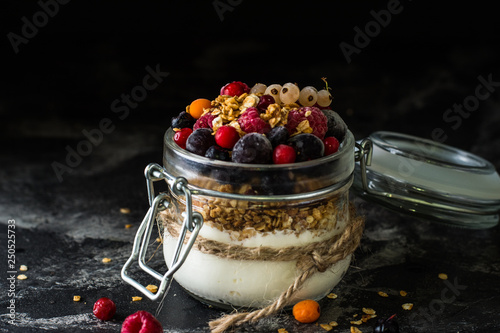 Yogurt with granola and berries in small jar  strawberries  blueberries.  black currant. sweetness. Homemade yogurt. Healthy food. Healthy meal. Vegetarian. Vegan. Healthy breakfast. Honey granola.