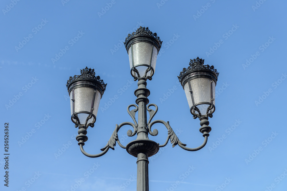street lamp in the old style against the blue sky