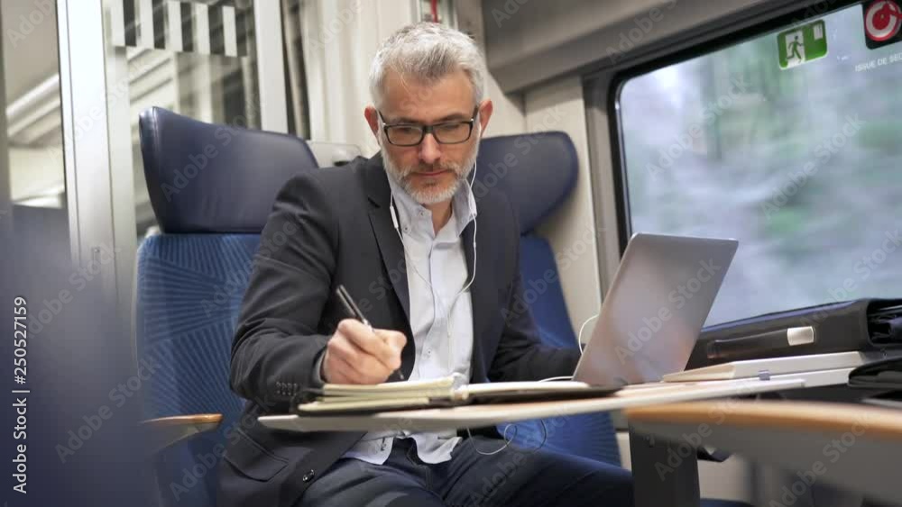 Businessman going to work by train, talking on phone