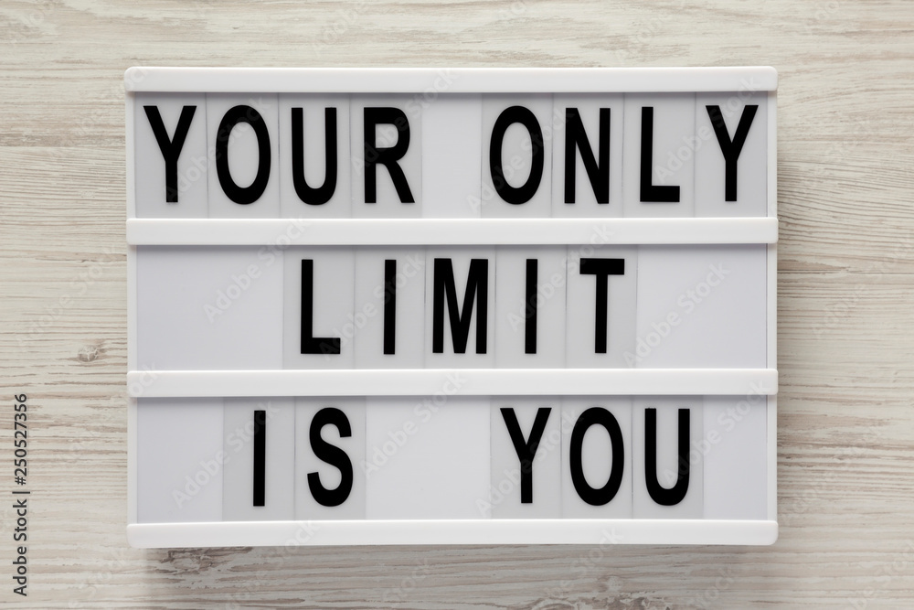 'Your only limit is you' word on modern board on a white wooden background, top view. From above, flat lay, overhead.