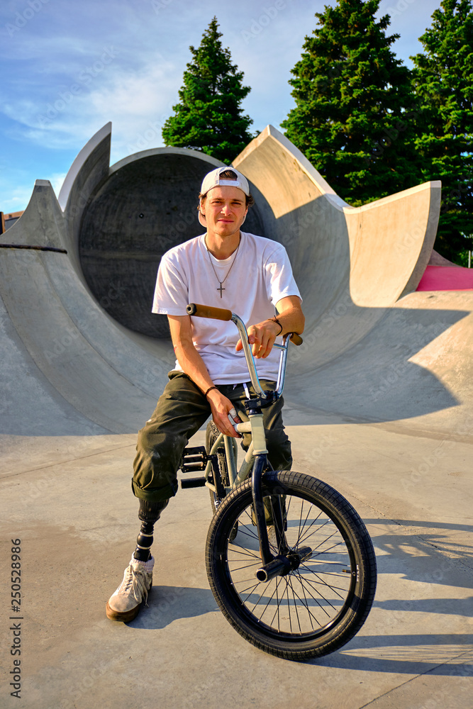 Portrait of BMX rider with prosthetic foot confidently posing on bike at  skateboard park Stock Photo | Adobe Stock
